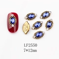 Macro view of vintage style 7x12mm royal blue oval nail art gem with gold border - 2550 Royal Blue