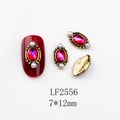 Macro detail of 7x12mm red oval gemstone nail charm with gold relief and pearls - 2556 AB Red