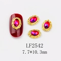Macro detail of red oval nail art gem with vintage gold relief frame on white background - 2542 Gold AB Red