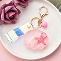 Detailansicht vom rosa Muschel-Schlüsselanhänger mit Glitzer, Laserband und Glöckchen - Rosa Muschel