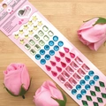 Macro view of colorful multi-shape dimensional crystal gemstone stickers on a pink card - Green Waterdrop