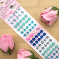 Macro detail of colorful dimensional crystal gem stickers in heart and star shapes - Flower Blue