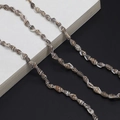 Detalle de cuentas de concha natural marrón y blanco en un cordón para anteojos - Negro