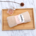 Close-up of rolled beige coral fleece towel with cloud label on a wooden tray - 35*75cm / Coffee