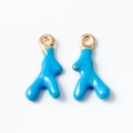 Macro shot of blue coral-shaped enamel pendants with gold metal rings on a white backdrop - Blue