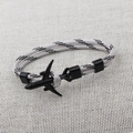 Detail of the black airplane charm with black and white braided paracord strap on fabric - Black White Striped (BPL2-17)