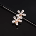 Close-up of elegant pearl flower hair clips with gold metal base on reflective black surface - Two Plum Blossoms