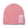 Detail of pink knit beanie showing rib-knit texture and sewn-on decorative white patch - Pink