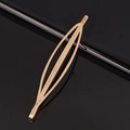 Minimalist gold-plated hollow shuttle-shaped metal hair clip on a black reflective surface - Leaf Shaped Metal Bobby Pin