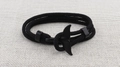 Close-up of black braided rope bracelet featuring a sleek whale tail metal clasp - Black Whale Tail Buckle / Black