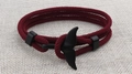 Macro detail of red woven rope bracelet with black whale tail charm and slider clasp - Black Whale Tail Buckle / Burgundy
