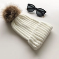 White ribbed knit beanie for women with a large brown faux fur pom-pom on top - White