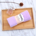 Detail of purple coral fleece towel rolled in paper packaging on a wooden tray - 35*75cm / Purple