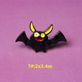 Macro detail of cartoon bat resin accessory with black body and large yellow eyes - Style 7 Black Bat