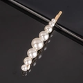 Detail shot of 7 white pearls set on a gold-plated metal hair clip over black surface - Gradient Pearl Flat Bobby Pin