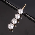 Macro shot of gold hair clip featuring four polished white pearls on a black background - Four Pearls Bobby Pin
