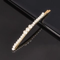 Close-up of golden metal hair clip featuring gradient white pearls on black surface - 3-Large 16-Small Pearl Bobby Pin