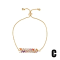 Macro detail of rainbow baguette cut zirconia on gold adjustable chain bracelet - Gold/Rainbow Baguette Zircon