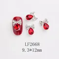 Détail macro du bijou d'ongle nœud avec strass goutte rouge, taille 9,3x12mm pour manucure - Larme Noeud Rouge Foncé (LF2668)