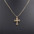 Gold cross necklace with micro-pave cubic zirconia on a black textured background - Style 0085