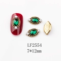 Macro detail of emerald nail charm 7x12mm with pearl accents and vintage gold base - 2554 Deep Green