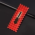 Detailed view of sweet red bead hair clip with golden metal base on black background - Red Rectangle