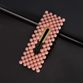 Close-up of sweet pink matte pearl hair clip with golden metal base on black background - Pink Rectangle