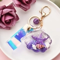 Detailansicht eines Muschel-Schlüsselanhängers mit lila Glitzersand und buntem Laserband - Violette Muschel