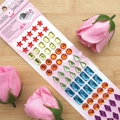 Close-up of colorful acrylic jewel stickers in star and drop shapes on pink card - Purple Waterdrop