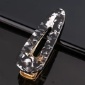 Macro view of marbled acetate hair clip with golden metal base and oval cut-out design - Acetate Black Marble Waterdrop