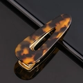 Macro shot of tortoiseshell acetate hair clip with golden metal spring fastener detail - Acetate Amber Tortoise Waterdrop