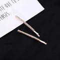 Détail d'un ensemble de deux barrettes en or rose serties de strass sur fond noir - Lot de 2 / Blanc