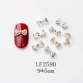 Détail du bijou d'ongle noeud strass AB 9x5mm sur une manucure rouge éclatante - Style Nœud Argenté Strass AB (LF2580)