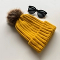 Winter knitted beanie for women in vibrant yellow with a fluffy brown faux fur pompom - Yellow