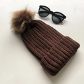 Winter knit beanie for women in dark brown featuring a large faux fur pompom decoration - Coffee