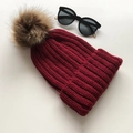 Winter knitted beanie in wine red featuring a large brown faux fur pom-pom on top - Burgundy