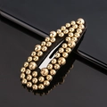 Detail of a black teardrop hair clip with elegant gold beaded studs on dark background - All Gold Beads