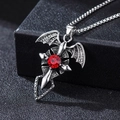 Gothic cross necklace with bat wings and a round red ruby stone on a black box - Red Zirconia Bat with Corn Chain