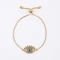 Detail of gold box chain bracelet featuring a blue cubic zirconia evil eye charm and slider - Gold/Long Eyelash Style