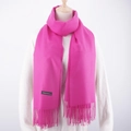 Detail shot of bright pink cashmere scarf with fringe and a premium quality brand label - Rose Red