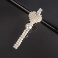 Macro detail of a pearl heart hair clip with silver base on a black reflective surface - Cupid Small Peach Heart Pin