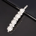 Elegant silver hair clip featuring multiple sizes of white faux pearls on a black background - Large 4-Flower Silver Bobby Pin
