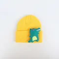 Detailansicht der gelben Strickmütze mit süßem grünen Krokodil-Aufnäher für Kinder - Cartoon Dinosaurier / Hellgelb