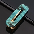 Détail macro d'une pince à cheveux en acétate marbré bleu sarcelle et base dorée - Acétate vert foncé carré