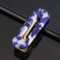 Detail of blue marble acrylic hair clip with golden metal clip on black surface - Acetate Blue White Marble Square