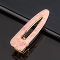 Détail d'une pince à cheveux en résine rose avec paillettes et clip en métal doré - Paillettes roses goutte d'eau