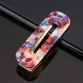 Detailed macro of marble texture acetate hair clip with golden metal base on black mirror - Acetate Rose Marble Square