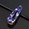 Macro shot of blue marble acetate hair clip with gold metal base on a black background - Acetate Blue White Marble Waterdrop
