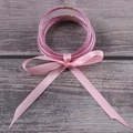 Detail of pink glitter jelly bracelets with ribbon bow on a wooden texture background - 5 Pieces / Pink