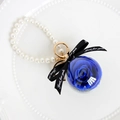 Preserved blue rose in clear ball keychain with white pearls and a black ribbon bow - Sapphire Blue